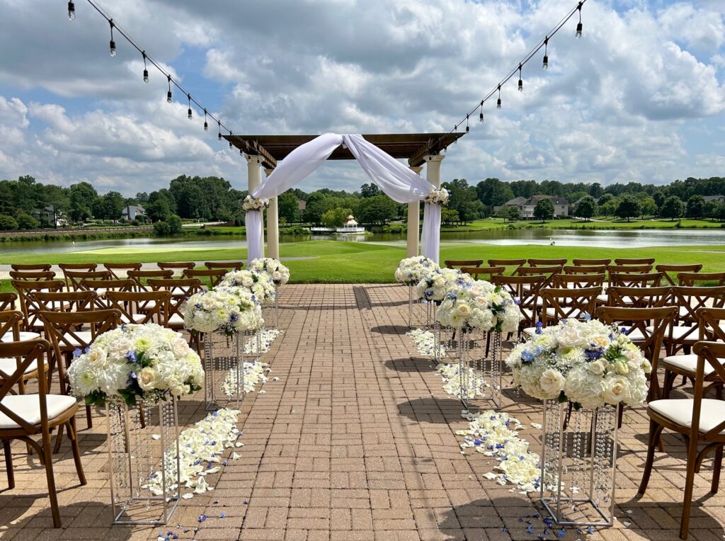 Country club ceremony pergola at The Dominion Club in Glen Allen, VA. White wedding flowers on stands. Pergola design.